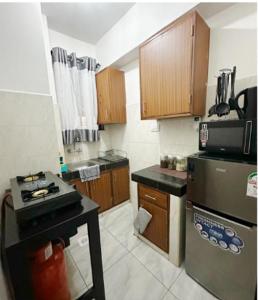 uma pequena cozinha com um fogão e um frigorífico em DelYves Homes em Mombasa