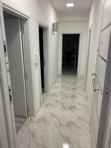 - un couloir avec des sols en marbre et des murs blancs dans l'établissement Oki doki 2, à Bitola