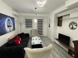 - un salon avec un canapé noir et une télévision dans l'établissement Oki doki 2, à Bitola