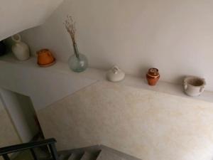 uma prateleira com cinco vasos sentados numa parede em Ca l'Èndula em Lucena del Cid