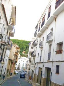 a street with buildings and a person walking down the street at Ca l'Èndula in Lucena del Cid
