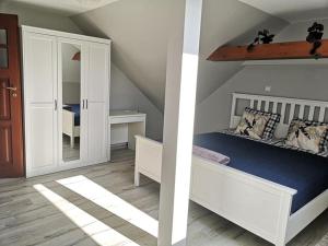 twee afbeeldingen van een slaapkamer met een bed en een spiegel bij Apartament Wodna Ostoja z pokojem zabaw in Buczki