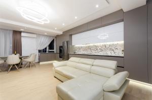 a living room with a white couch and a table at Luxury apartment close to the city centre in Chişinău