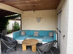 niebieska kanapa na patio z krzesłami i stołem w obiekcie Suite parentale avec piscine privée w mieście Moussan