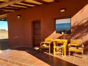 a patio with chairs and a table and a window at Cabañas Cañones del Triásico in Villa Unión