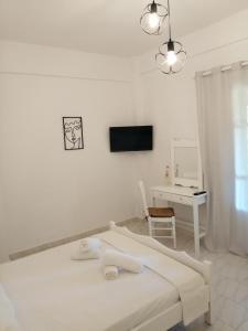 Habitación blanca con cama y escritorio en Pericles Apartment en Dassia