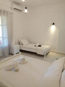 een witte kamer met een bed en een bank bij Pericles Apartment in Dassia