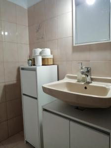 a bathroom with a sink and a mirror and towels at Pericles Apartment in Dassia