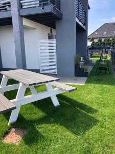 a picnic table on the lawn of a house at Sea Breeze - 6 Personen Ferienhäuser in Rewal