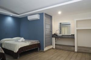 - une chambre bleue avec un lit et un lavabo dans l'établissement Hotel El Detalle, à Ciudad Valles