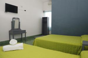 ein Hotelzimmer mit 2 Betten und einem TV in der Unterkunft Hotel El Detalle in Ciudad Valles
