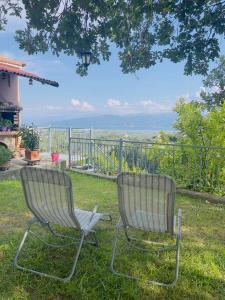 dos sillas sentadas en el césped frente a una valla en Sea view Villa Dafnes, en Nafpaktos