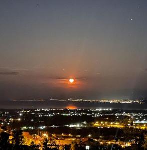 una vista de la ciudad por la noche con el sol en el cielo en Sea view Villa Dafnes, en Nafpaktos