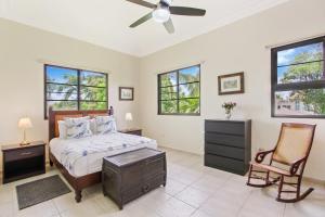 una camera con letto, sedia e finestre di Spacious 4 Bedroom Villa with Pool, Touring Cart & Maid a Punta Cana