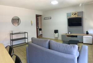 sala de estar con sofá azul y TV en Hermoso depto en la 5ta sección en Mendoza