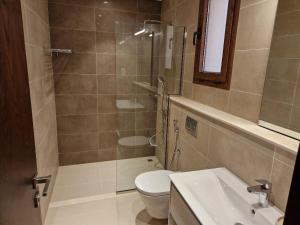 een badkamer met een douche, een toilet en een wastafel bij Glory Salalah Miko 2 in Salalah