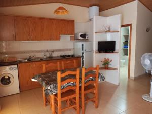 a kitchen with a table and chairs and a refrigerator at Casa Esteban in Villanueva de Viver