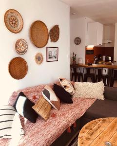 a room with a couch and a table with hats on the wall at CASA DAHLIA - Charmant appartement équipé avec grande terrasse in Marseillan