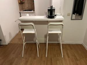 een keuken met 2 stoelen en een tafel met een magnetron bij Appartements Brussels in Brussel