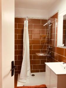 a bathroom with a shower with a white shower curtain at CASA DAHLIA - Charmant appartement équipé avec grande terrasse in Marseillan