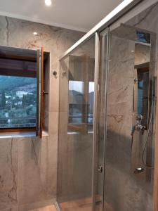 W łazience znajduje się prysznic ze szklanymi drzwiami. w obiekcie BELLΙSIMO3 w mieście Parga