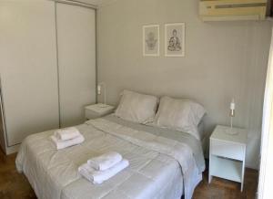 1 dormitorio blanco con 2 toallas en una cama en Hermoso depto en la 5ta sección en Mendoza