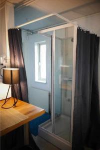 a glass shower in a room with a desk at The Northern Light Apartment in Jukkasjärvi