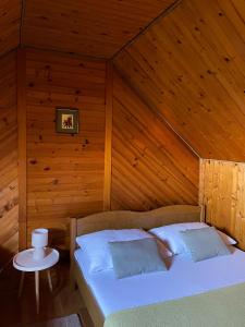 a bed in a room with a wooden wall at Tomasova kuća in Križevci