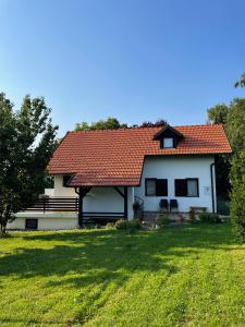 Casa blanca con techo rojo y patio en Tomasova kuća, en Križevci