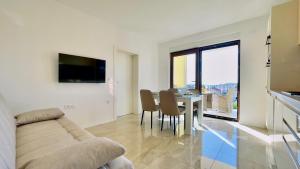 a living room with a couch and a table with chairs at Apartments Sunflower in Dramalj
