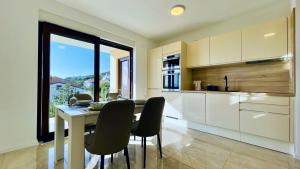 a kitchen with a table and chairs in a kitchen at Apartments Sunflower in Dramalj