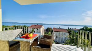 a balcony with a table with a bowl of fruit on it at Apartments Sunflower in Dramalj