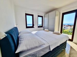a bedroom with a bed and a large window at Apartments Sunflower in Dramalj