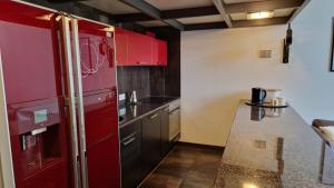 a kitchen with red cabinets and a red refrigerator at Modern 2-level Loft Apartment - Tymienieckiego, Łódź city center in Łódź