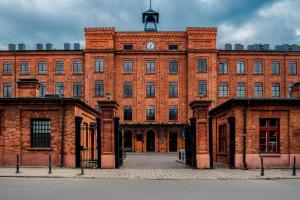 un gran edificio de ladrillo con una torre de reloj en la parte superior en Modern 2-level Loft Apartment - Tymienieckiego, Łódź city center, en Łódź