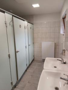 ein Badezimmer mit zwei Waschbecken und Ställen in der Unterkunft Autokemp / Speleocamp Malužiná in Malužiná