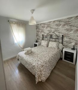 - une chambre avec un lit et un mur en briques dans l'établissement Apartamento Henko, à Huelva