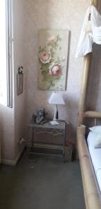 sypialnia ze stołem z lampką i obrazem w obiekcie Côté jardin w mieście Périgueux