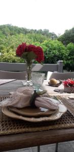 un tavolo con un vaso di rose rosse sopra di Côté jardin a Périgueux