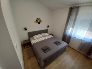 a bedroom with a bed with two pillows on it at Apartments LAURA in Fažana