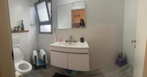 a white bathroom with a sink and a toilet at נקודות ריפוי טירת כרמל in Tirat Karmel +10 photos