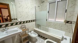 y baño con lavabo, bañera y aseo. en Casa Rural Las Camelias, en Herrera del Duque