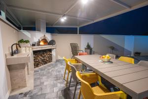 a kitchen and dining room with a table and yellow chairs at Villa Ivana in Ljubuški