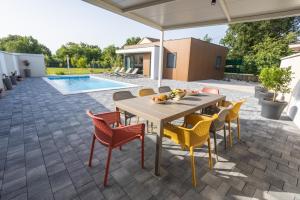 a patio with a table and chairs and a pool at Villa Ivana in Ljubuški