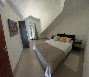 a bedroom with a large bed in a attic at Apartments Pisačić in Bibinje