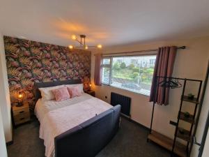 a bedroom with a bed and a large window at Bowness - 3 Bed - Hot Tub House in Bowness-on-Windermere