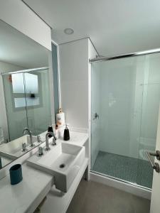 y baño blanco con lavabo y ducha. en Torre Green Life FullAmenities, en Punta del Este