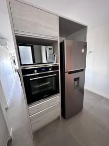 een keuken met een roestvrijstalen koelkast en een magnetron bij Torre Green Life FullAmenities in Punta del Este