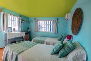 ChuburnáにあるBeach houseの緑の壁のベッドルーム1室(ベッド2台付)