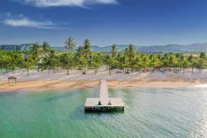 two people on a pier in the water near a beach at Minh Phu Quoc lodge beach swimming pool in Phu Quoc